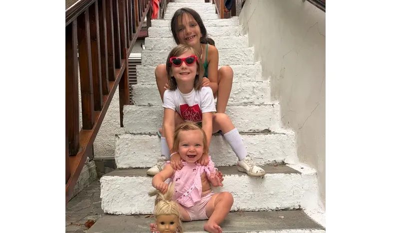 Three young children sitting on outdoor steps