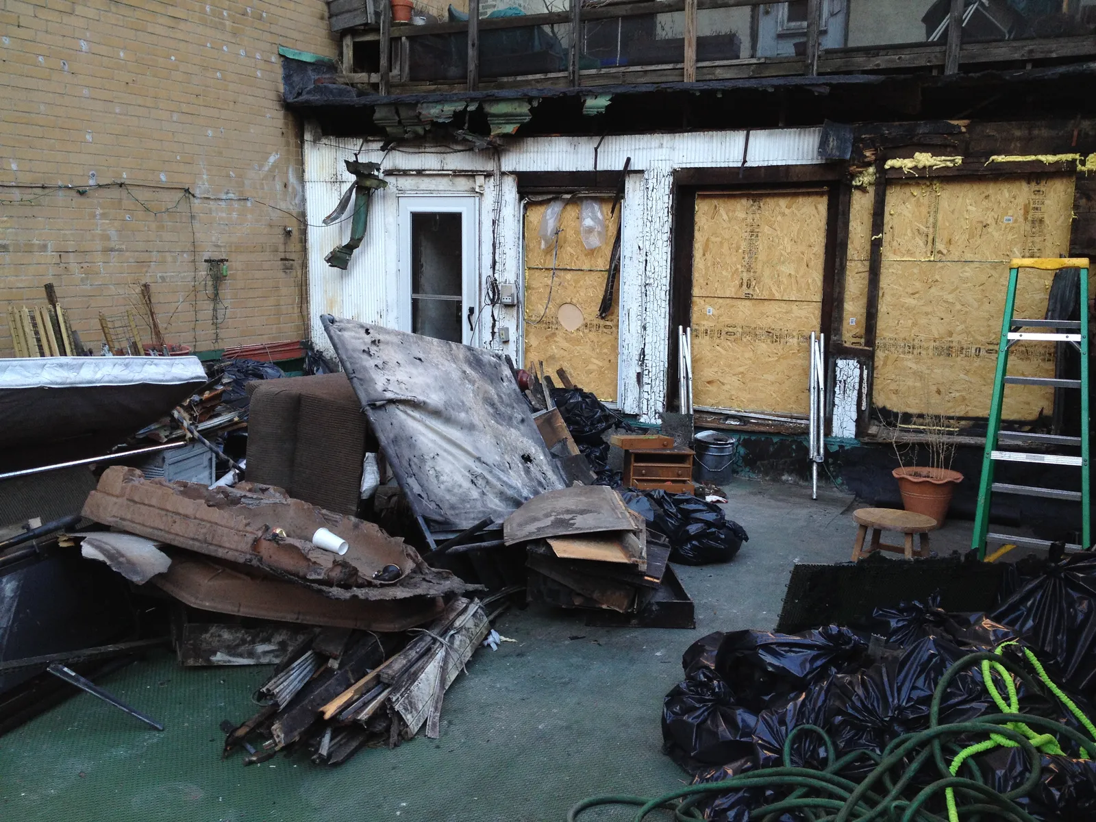 Burned debris piled behind the fire-damaged Third Avenue dog training studio