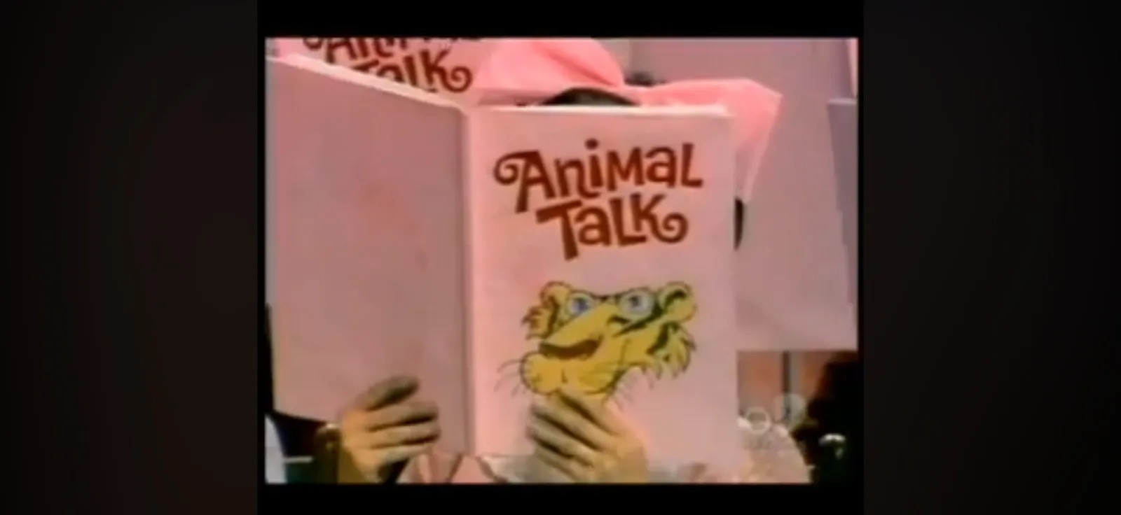 A person reading a book called Animal Talk